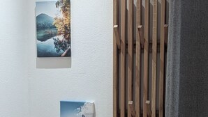 Eine Wand mit zwei gerahmten Bildern und einer Holzleiste.