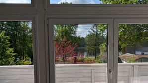 A covered outdoor area with a view of a lake and trees.