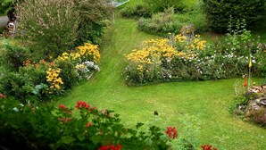 A lush garden with a variety of flowers and a well-maintained lawn. - Seitz 1 in Bayerisch Eisenstein by Interhome (Bayerisch Eisenstein)