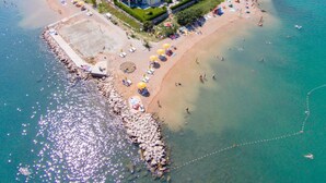 An aerial view of a coastal area with a beach, a row of houses, and boats. - Biserka by Interhome (Krk/Čižići)