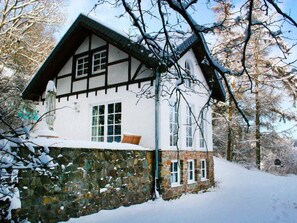 A traditional half-timbered house with a stone foundation, large windows, and a snow-covered landscape. - Fachwerkhaus mit Garten, Grill und Terrasse by Interhome (Blankenheim)