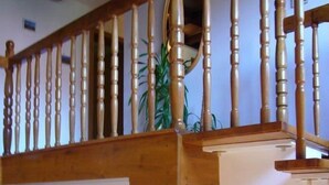 A wooden staircase with a handrail, a wooden door with glass panels, and a bulletin board with notices. - "Villa Petra" mit eigener Terrasse by Interhome (Karpacz)