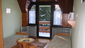 A cozy cabin with two wooden beds, a small table with a chair, a television, and a view of a snowy landscape through the windows. - "Villa Petra" mit eigener Terrasse by Interhome (Karpacz)