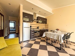 Eine moderne Küche mit Essbereich, einer Couch und einem Schachbrettmuster-Boden.