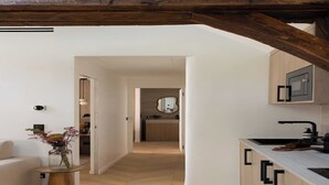 Una cocina moderna con armarios de madera, microondas integrado y un lavamanos negro.