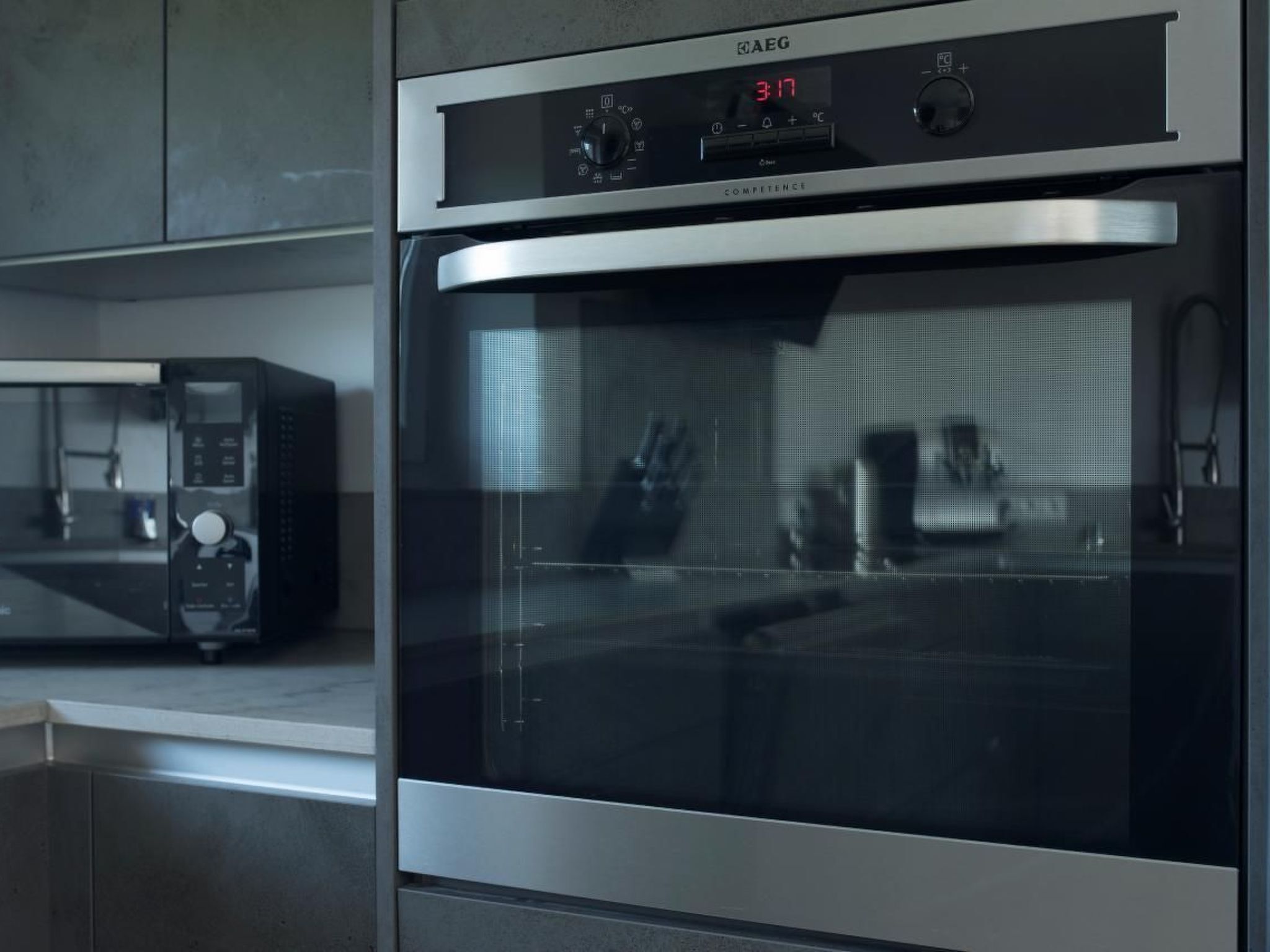 Una cocina moderna con horno y microondas de acero inoxidable.