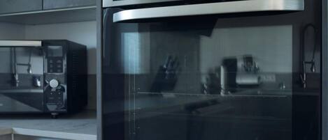 Una cocina moderna con horno y microondas de acero inoxidable.