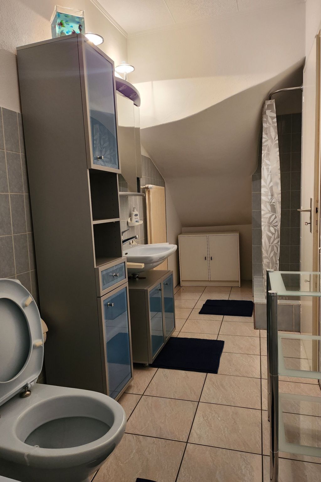 Pieni kylpyhuone, jossa on wc, pesuallas ja kaappi.
