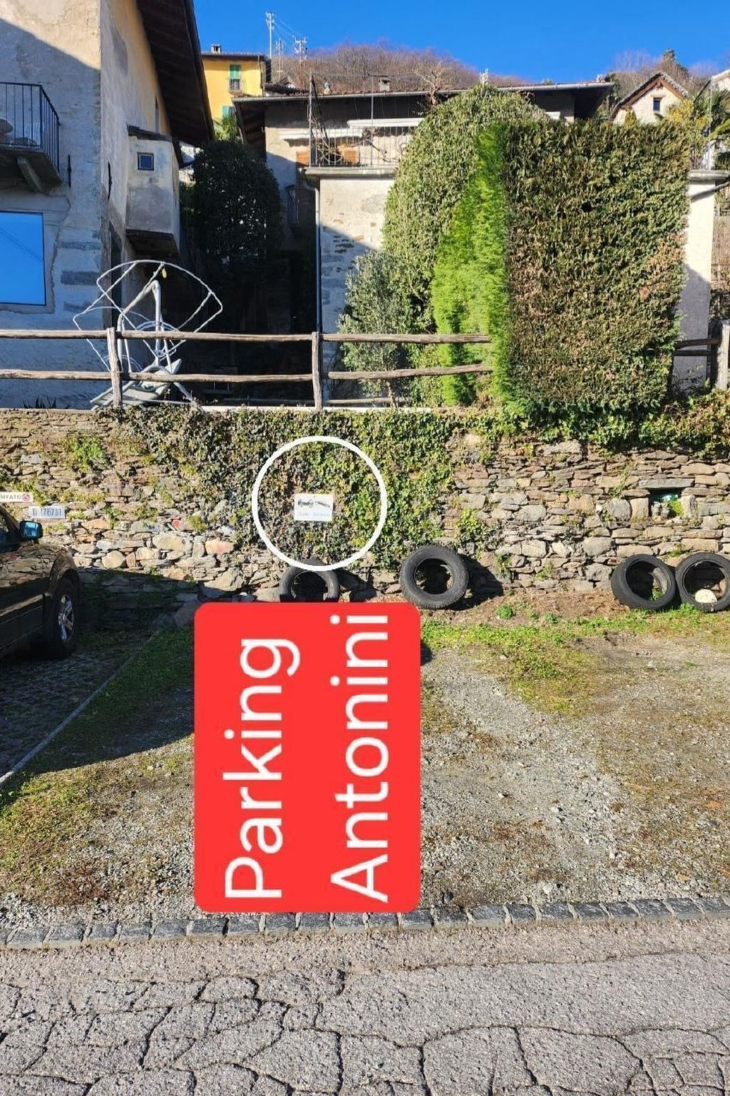 Una señal de estacionamiento roja con el texto 'Parking Antonini' en letras blancas.