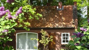 A brick house with a tiled roof, a large window, and a door. - Alte Kate by Interhome (Thomasburg)