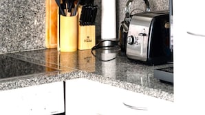 A kitchen counter with a toaster, a knife block, and a bottle of hand soap. - See-Penthouse by Interhome (Brissago)
