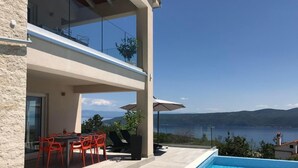 A modern house with a pool, outdoor seating, and a view of the sea. - Vacation home Stepča by Interhome (Brseč)