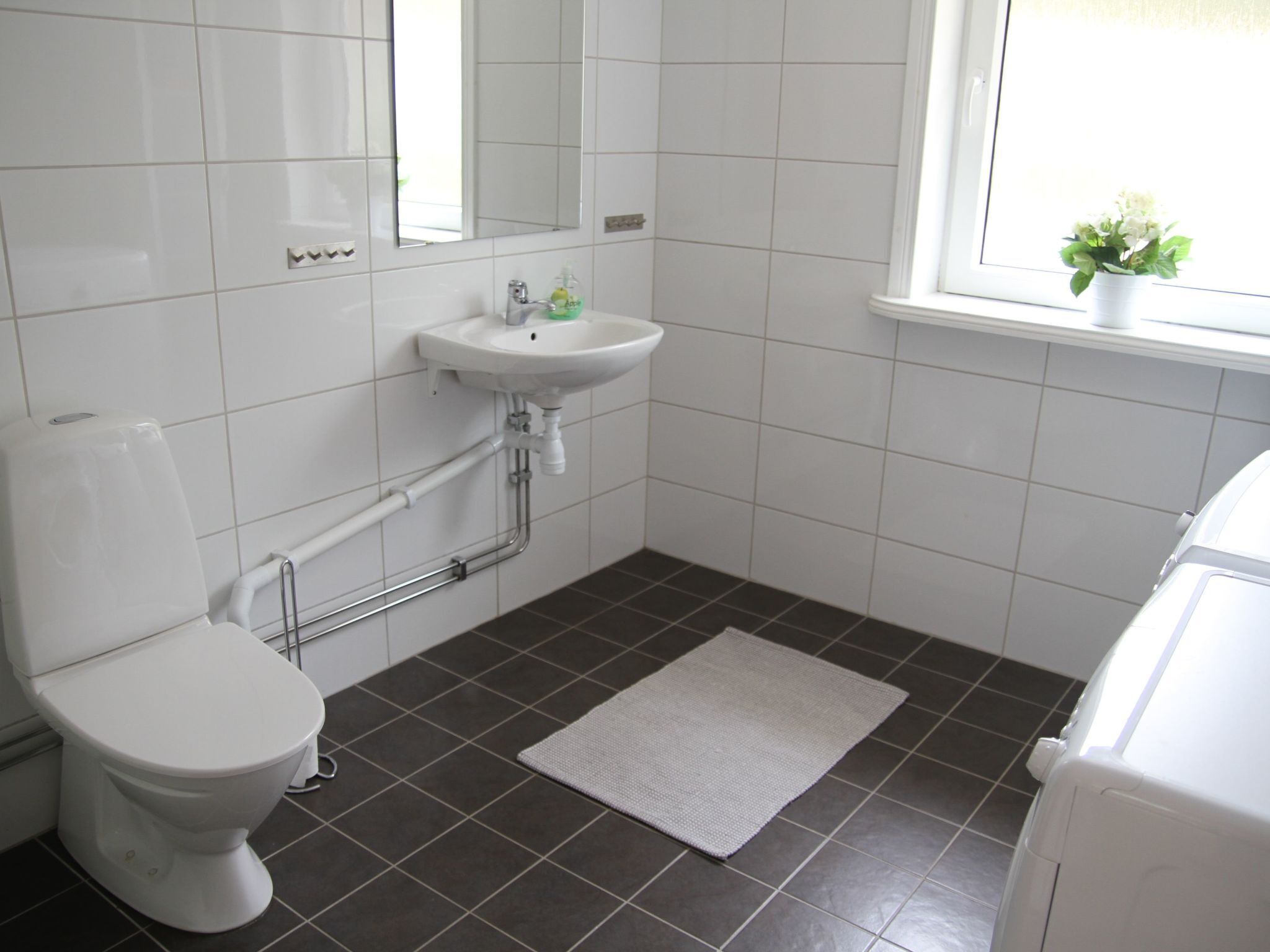 Un baño con inodoro, lavamanos y ventana.