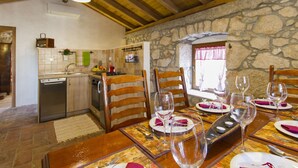 A rustic dining area with wooden chairs and a stone wall backdrop. - Geräumiges Ferienhaus in Brseč mit Privatem Pool by Interhome (Brseč)