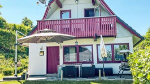 Una casa de dos pisos con un balcón, una antena parabólica y un letrero con el número 101.