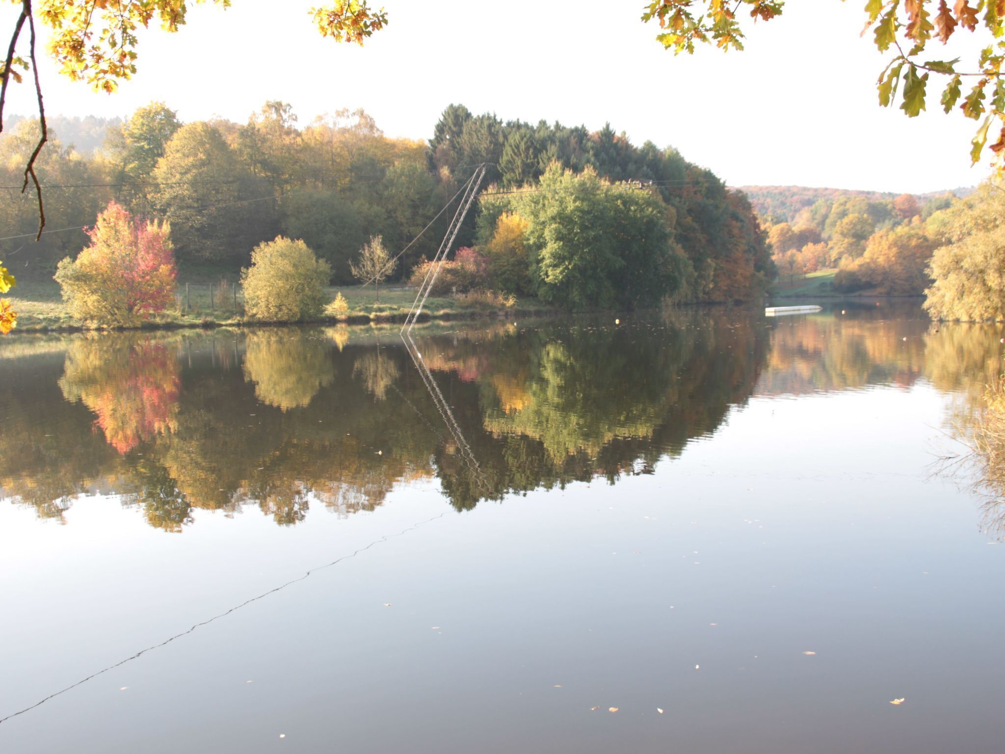 Un lago tranquillo con riflessi di alberi e un cielo sereno.
