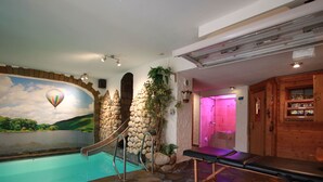 A spa area with a hot tub, a massage table, and a stone wall. - Simonis Privatpool by Interhome (Zell (Mosel))