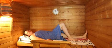 A sauna room with wooden walls and benches.
