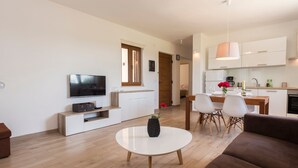Ein modernes Wohnzimmer mit Flachbildfernseher, Couchtisch und Sofa.