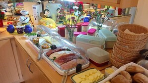 Un bufé con una variedad de alimentos, incluyendo carnes, quesos y panes.