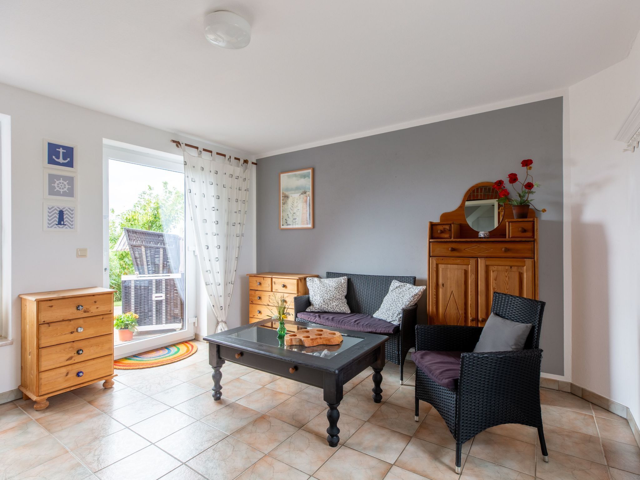 A living room with a sofa, a coffee table, a wooden cabinet, and a chair.