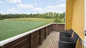 A wooden deck with a view of a green field and trees. - Rosenhill by Interhome (Pauliström)