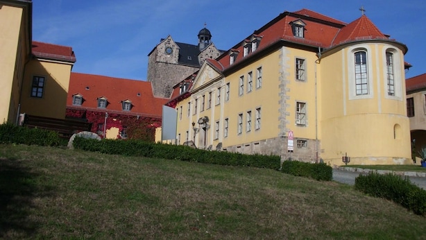 A historic building with a red roof, yellow facade, and a clock tower. - in Radisleben mit Garten und Terrasse by Interhome (Ballenstedt)
