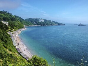 A coastal view with a beach, buildings on a hillside, and clear blue water. - Gemütliches Familienhaus am Meer by Interhome (Torquay)
