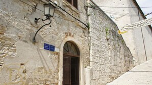 A stone building with a wooden door and a sign indicating it is an apartment. - Stilvolle Wohnung in Arena mit großer Terrasse by Interhome (Pula)