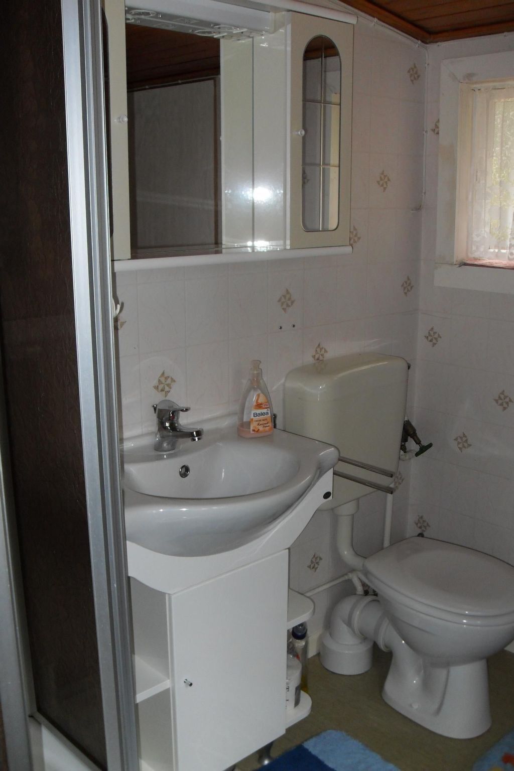 A bathroom with a white sink, a toilet, and a mirror above the sink.