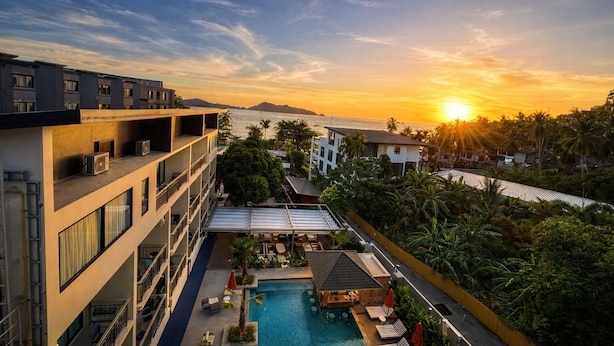A hotel with a rooftop pool, a view of the sunset, and a body of water in the background. - Aqua Maya Phuket (Patong)