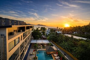 A hotel with a rooftop pool, a view of the sunset, and a body of water in the background. - Aqua Maya Phuket (Patong)