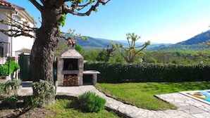 A stone barbecue area with a chimney, surrounded by a well-maintained lawn and a large tree. - "Valentino" mit Blick auf das Wasser by Interhome (Motovun)