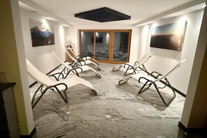 Una habitación con sillones reclinables, un tragaluz en el techo y vistas a través de un ventanal.