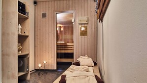 Un sauna avec des bancs en bois, un chauffage intégré aux bancs et un panneau indiquant qu’il s’agit d’un sauna.