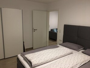 A bedroom with a bed, a wardrobe, and a door leading to another room. - Götterlay by Interhome (Bruttig-Fankel)