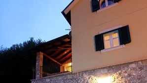 Ein Gebäude aus Stein mit Pool, Liegestühlen und einer Treppe, die zu einer oberen Ebene führt.