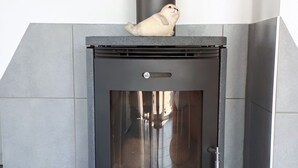 Una chimenea moderna con puerta de vidrio, una chimada y un detalle decorativo en la parte superior.