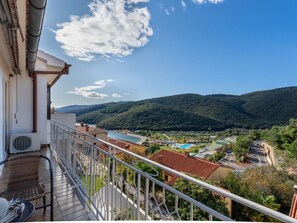 A balcony with a view of a mountainous landscape, a swimming pool, and a road. - Wohnung "Leonardo" mit Blick auf das Wasser by Interhome (Rabac)