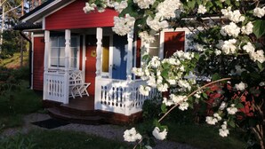 A red house with white shutters, a porch, and a white fence. - Karlsson by Interhome (Fågelfors)