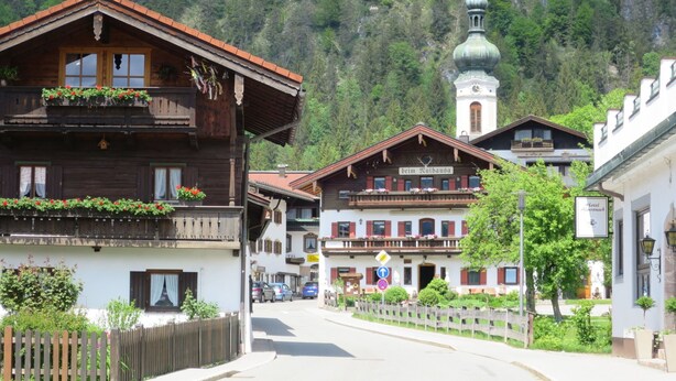 Un bâtiment traditionnel en bois, doté de balcons, d’un clocher et d’une enseigne indiquant qu’il s’agit d’un hôtel.