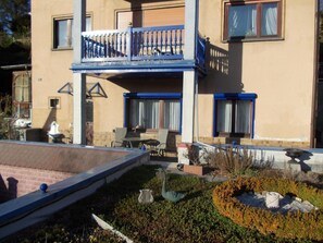 A two-story building with a balcony, outdoor seating, and a garden area with sculptures. - Monterosa in Baden-Baden by Interhome (Baden-Baden)