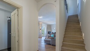 Ein geräumiger Wohnbereich mit Treppe, Kamin und einer Couch.