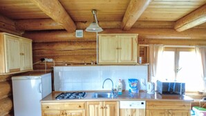 A compact kitchen with wooden cabinets, a built-in dishwasher, a gas stove, and a sink. - Holzhäuschen Goral by Interhome (Kopalino)