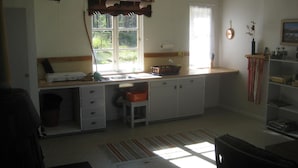 A compact kitchen with a window, a sink, and a small dining area.