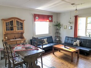A cozy living room with a wooden dining table, a sofa, and a cabinet. - in Arvidsjaur mit eigener Sauna by Interhome (Arvidsjaur)