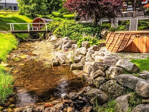 A small stream with rocks and a wooden bridge. - Exklusives Ferienhaus mit Schwimmbad direkt am Wasser by Interhome (Szklarska Poreba)