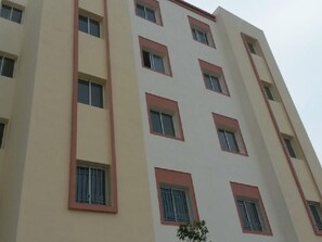 A multi-story building with a beige facade and red window frames. - Appartement Essalam by Interhome (Agadir)