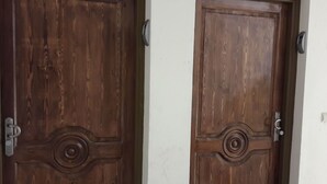 Two wooden doors with a classic design, each featuring a circular motif and a metal handle. - Résidence Mogador 1 by Interhome (Agadir)