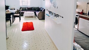 A spacious living area with a red rug, a ceiling fan, and a dining area with a table and chairs. - Wohnung "Loft in Tanger" by Interhome (Tanger)